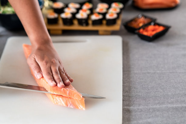 女厨师切生鲑鱼。图片下载