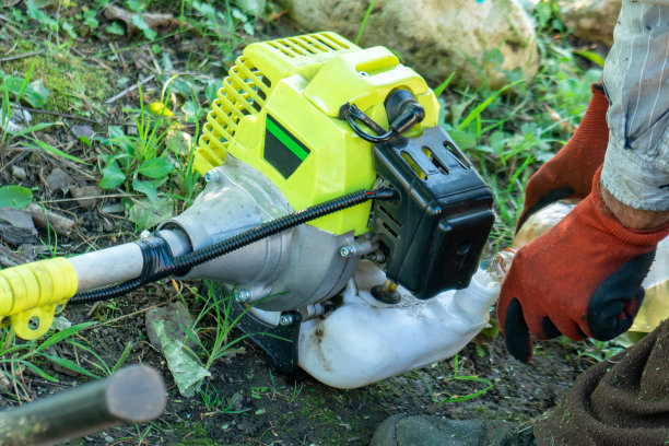 农民给田野里的修剪机的油箱加汽油图片下载