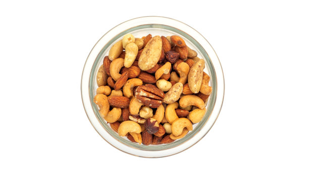 在白色背景的碗里烘烤混合坚果。图片下载