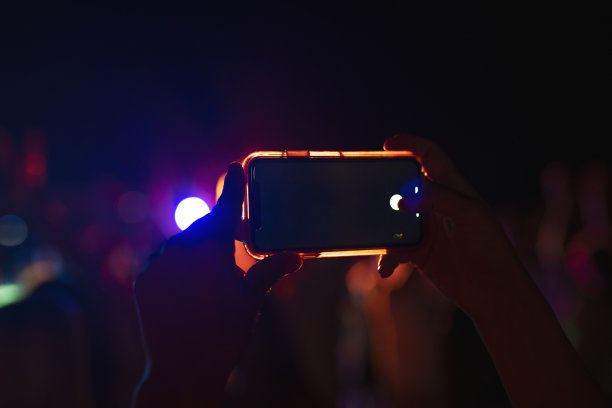 在音乐节上制作照片的手的特写。图片下载