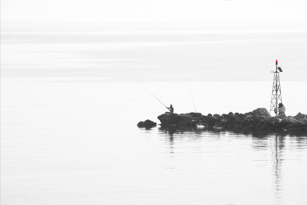 在清晨的时间和雾。剪影渔民与鱼竿和灯塔在码头上。极简主义。夏天的风景图片下载
