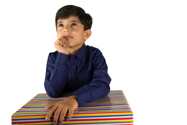 盒子里是什么?一个小男孩拿着一份礼物，注视着一张库存照片图片下载