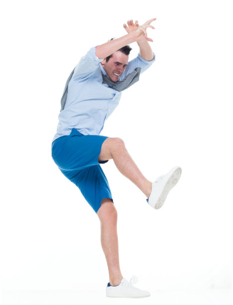 1人/一人/全身/侧视图/侧面视图20-29岁的成年英俊的人白人男性/年轻男子跳/半空中在白色背景，穿着短裤/卷起袖子/毛衣/帆布鞋图片下载