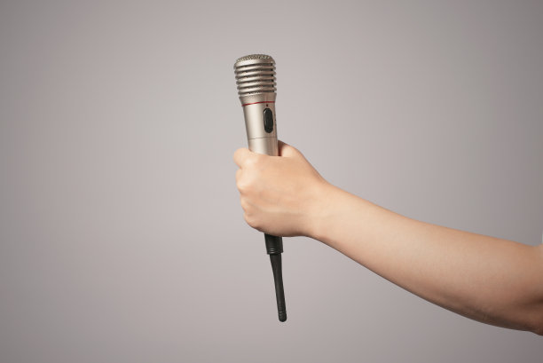 手里拿着麦克风的女人。图片下载
