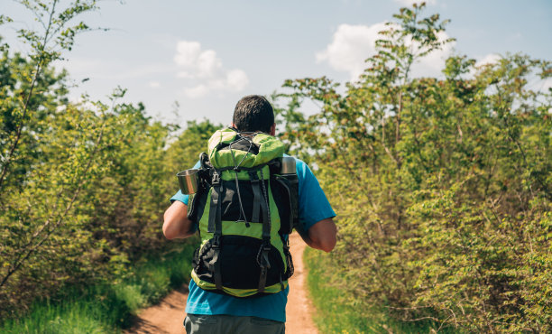 男性徒步旅行者在山间漫步图片下载
