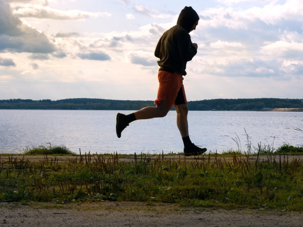 日落时分在河边慢跑的男子图片下载