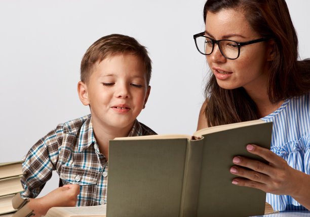 老师和小男孩在白色背景上看书图片下载