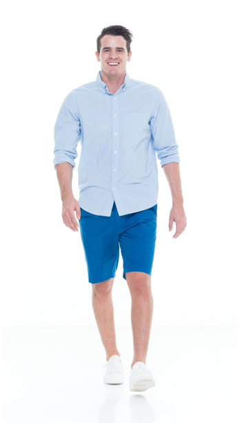 一人/一人/全身/正面20-29岁的成年英俊的人白人男性/年轻男子走在白色背景穿着短裤/卷起袖子/帆布鞋谁是微笑/快乐/愉快图片下载