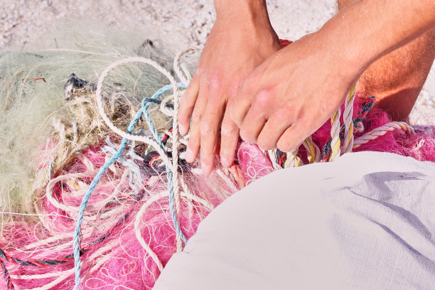 一堆乱七八糟的渔网、塑料绳子和其他碎片被冲上了海岸海滩。图片下载