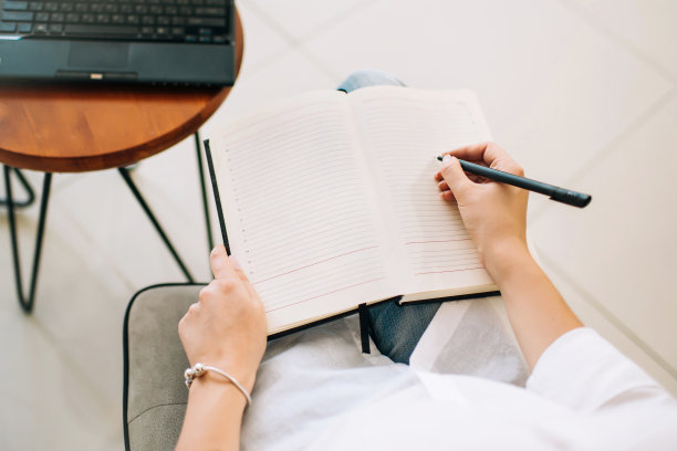 女人的手在记事本上写字，俯视图。图片下载