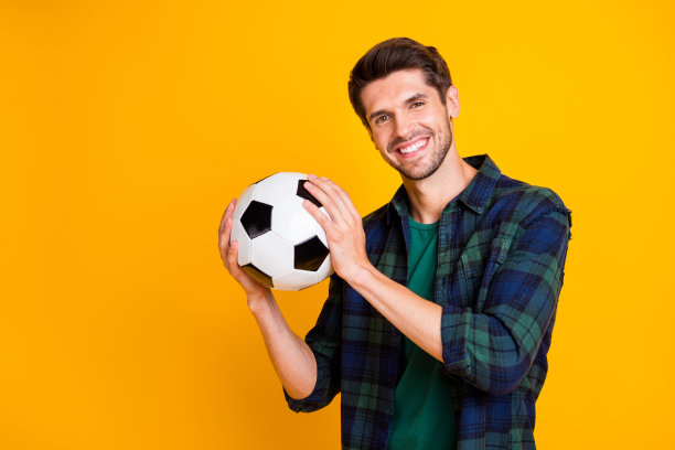 酷家伙的照片与白色和黑色的足球兴奋开始比赛穿休闲格子衬衫孤立黄色背景图片下载