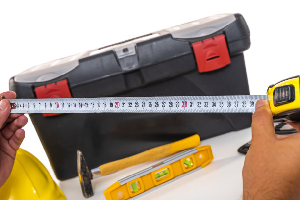 黄色轮盘，工具箱锤子，水平和部分安全帽在白色背景图片下载