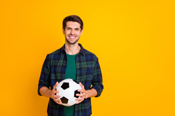 酷家伙的照片与白色和黑色的足球兴奋开始比赛穿休闲格子衬衫孤立黄色背景图片下载