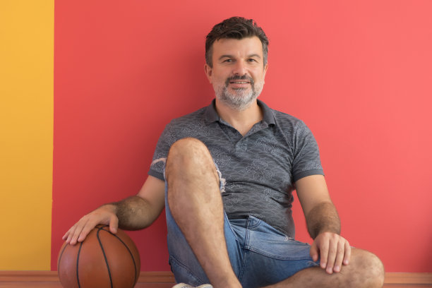 成熟的男人在篮球场放松。图片下载