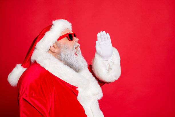 搞笑圣诞老人尖叫促销新年决议戴眼镜眼镜戴明亮的帽子孤立在红色背景的侧面照片图片下载