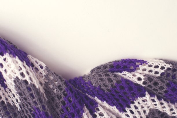 紫色和白色条纹钩针毛衣在浅的背景。纹理细节特写。图片下载