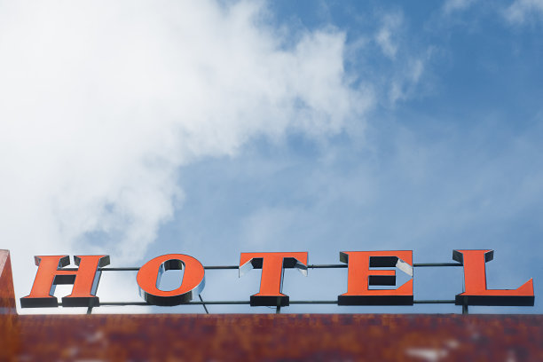 酒店的招牌在阳光下，背景是清澈的蓝天。图片下载