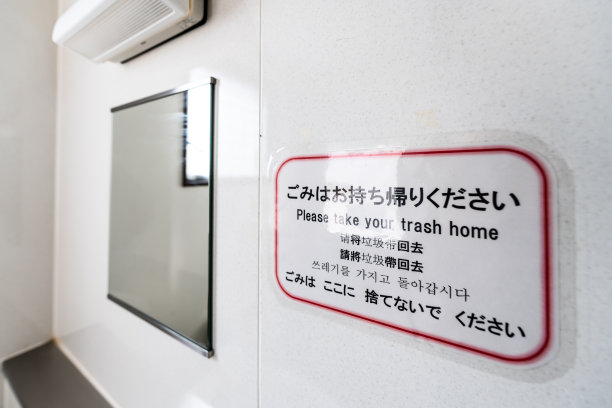 在日本，用中文、英文、韩文和日语写着“请把垃圾带回家”的厕所或厕所标志图片下载