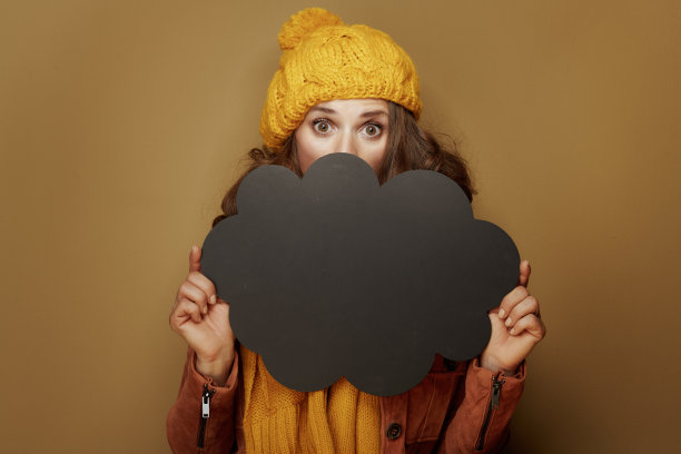 惊讶的女人躲在云形的空白黑板后面图片下载