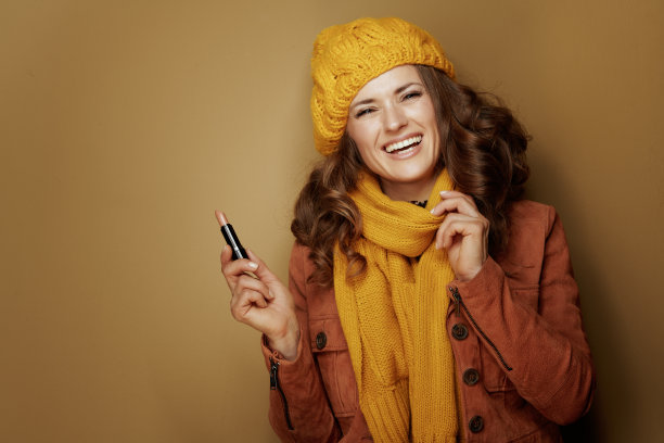 幸福的女人涂着干净的口红，映衬着古铜色的背景图片下载