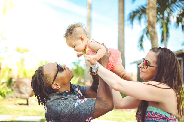 一对黑白混血夫妇和他们可爱的宝贝女儿在外面玩，可爱的一家人在度假图片下载