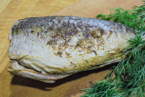 桌子上放着烤炉里烤好的金枪鱼和绿色的莳萝图片下载