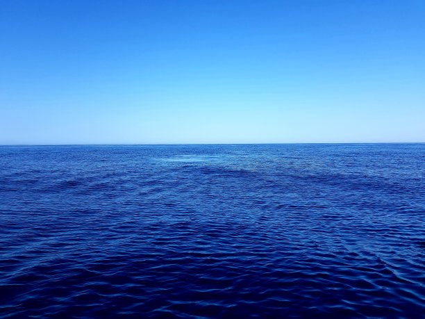 深蓝色的大海映衬着蓝色的天空图片下载