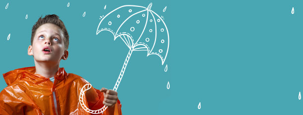 一个男孩穿着橙色雨衣，拿着一把彩伞站在雨中图片下载