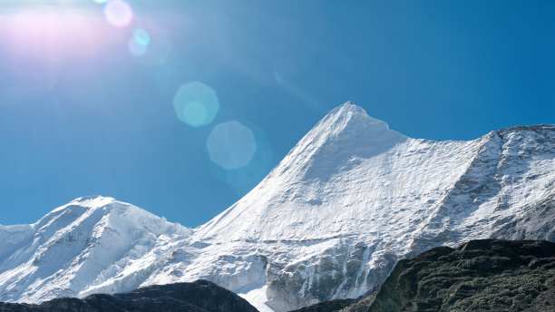中国四川稻城亚丁国家公园碧空背景下的Jambeyang峰上的太阳耀斑。图片下载