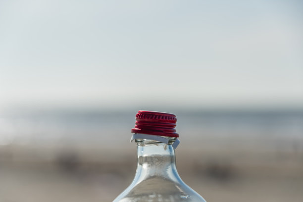 在海边开着红色的瓶盖，映衬着模糊的背景图片下载