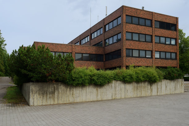 阴冷的办公室砖建筑和混凝土花坛与植物图片下载