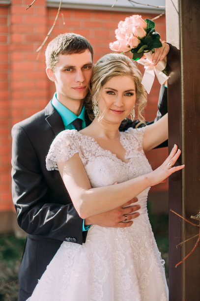 新娘和新郎在公园接吻。一对新婚夫妇新娘和新郎在一个婚礼在自然绿色的森林正在亲吻照片肖像。婚礼的夫妇图片下载