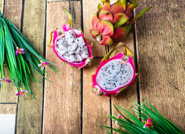 火龙果或火龙果带切片，孤立于观赏叶背景上，食用异域热带营养食品图片下载