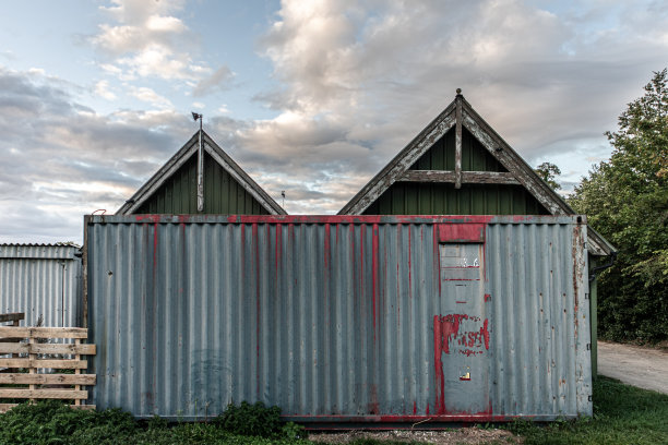 农场建筑前的旧生锈的金属集装箱图片下载