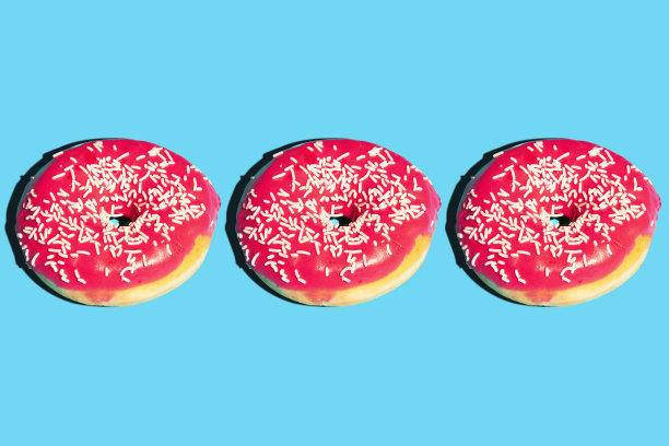 创意图案与粉色甜甜圈孤立在蓝色背景。食物照片海报的概念。食物平。创造性的布局。食品的海报。图片下载