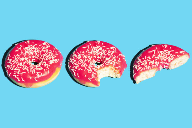 创意图案与粉色甜甜圈孤立在蓝色背景。食物照片海报的概念。食物平。创造性的布局。食品的海报。图片下载