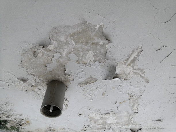 在射灯的背景下，旧的白色天花板正在脱落。图片下载