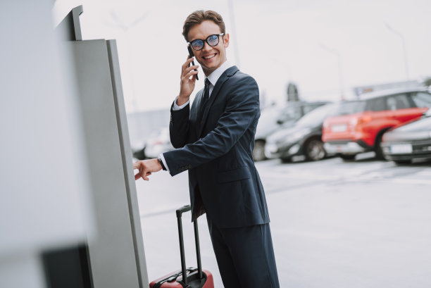 戴眼镜的微笑男子在室外的停车计费器里付款图片下载