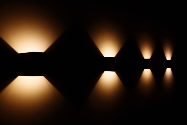 在黑暗的墙壁上的立方体形式的现代灯的照片。图片下载