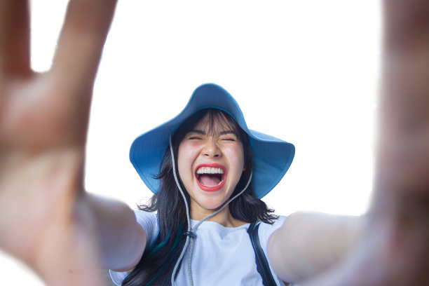 近距离拍摄美丽的亚洲女性步行到古老的寺庙，并通过网络媒体拍摄自己。她是一个美丽的微笑。玩得开心，牙齿干净。图片下载