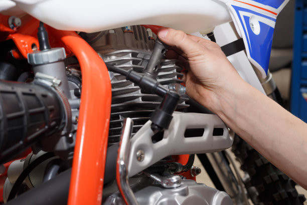 摩托车手更换、检查摩托车上的点火插头。图片下载