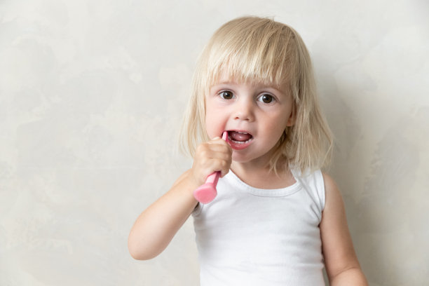 小女孩用牙刷刷牙。牙科健康。在隔离图片下载