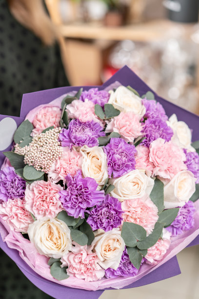 美丽的新鲜切花束混合在女人的手。花店花匠的工作。柔和的色调颜色素材图片