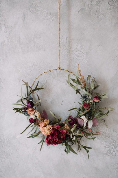 用玫瑰、绣球花和桉树在灰色的墙壁背景上制作的美丽的手工制作的永久干燥的花环图片下载