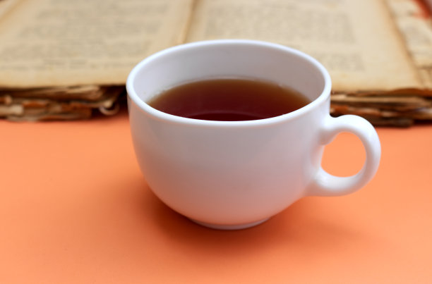 秋天的花园早餐。一杯茶，一本旧书。图片下载