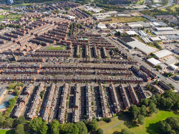 这是英国西约克郡利兹市比斯顿镇的航拍照片，在明媚的阳光下，无人机拍摄的典型英国住宅小区内的一排房屋。图片下载