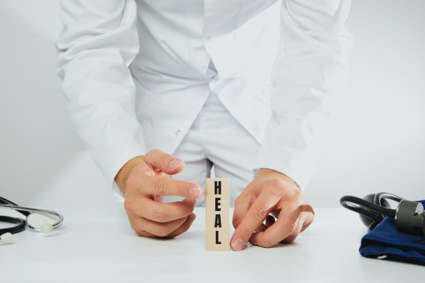 医生手里拿着一块写着“治愈”字样的块。图片下载