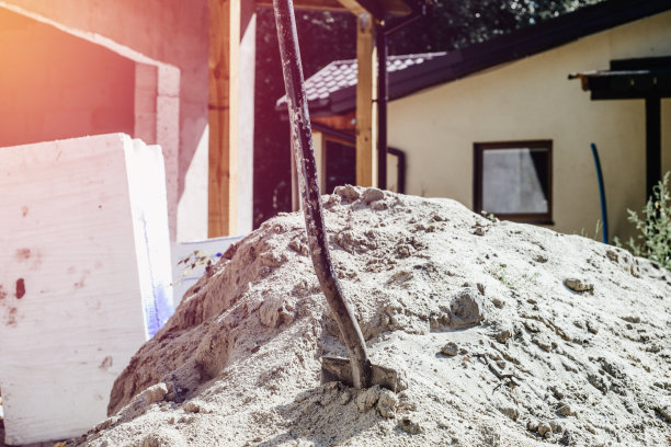 铲进堆积的沙子。建筑的概念，建造房子，公寓。建造自己的家时需要的设备。图片下载