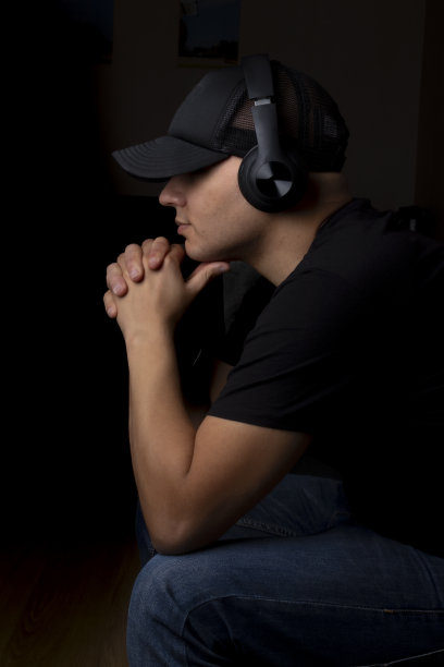 年轻人在黑暗中戴着耳机听音乐图片下载