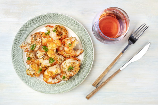 用一杯玫瑰酒煎虾，在浅蓝色背景上从顶部拍摄图片下载